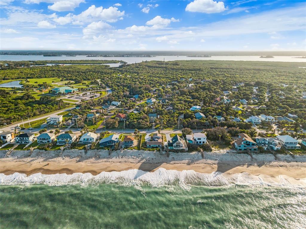 An aerial view shows a row of beachfront houses along a sandy coastline near trees — 6850 S HIGHWAY A1A, MELBOURNE BEACH, FL