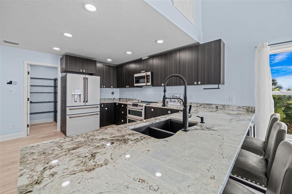 A two-story house with light siding, a garage, and a concrete driveway at sunset — 6850 S HIGHWAY A1A, MELBOURNE BEACH, FL