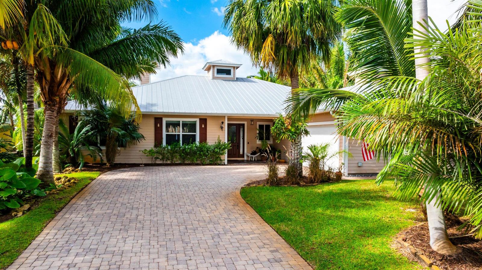 A single-story house with a metal roof, palm trees, and a paved driveway — 2672 NW South Shore Road, Stuart FL 34994, STUART, FL