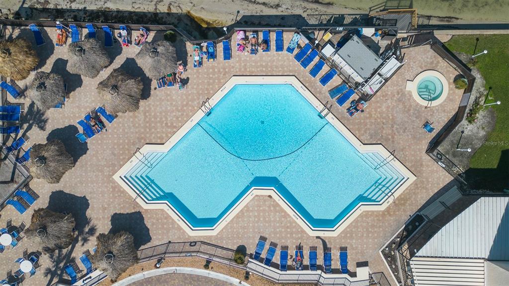 An aerial view shows a swimming pool with a hot tub and lounge chairs — 5510 PUERTA DEL SOL BOULEVARD S UNIT 132, ST PETERSBURG, FL