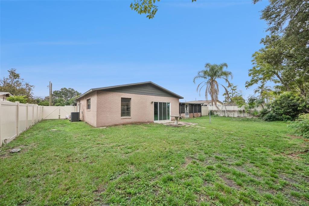 The backyard features a brick house with a sliding glass door and a vinyl fence — 204 W BUCHANON AVENUE, ORLANDO, FL