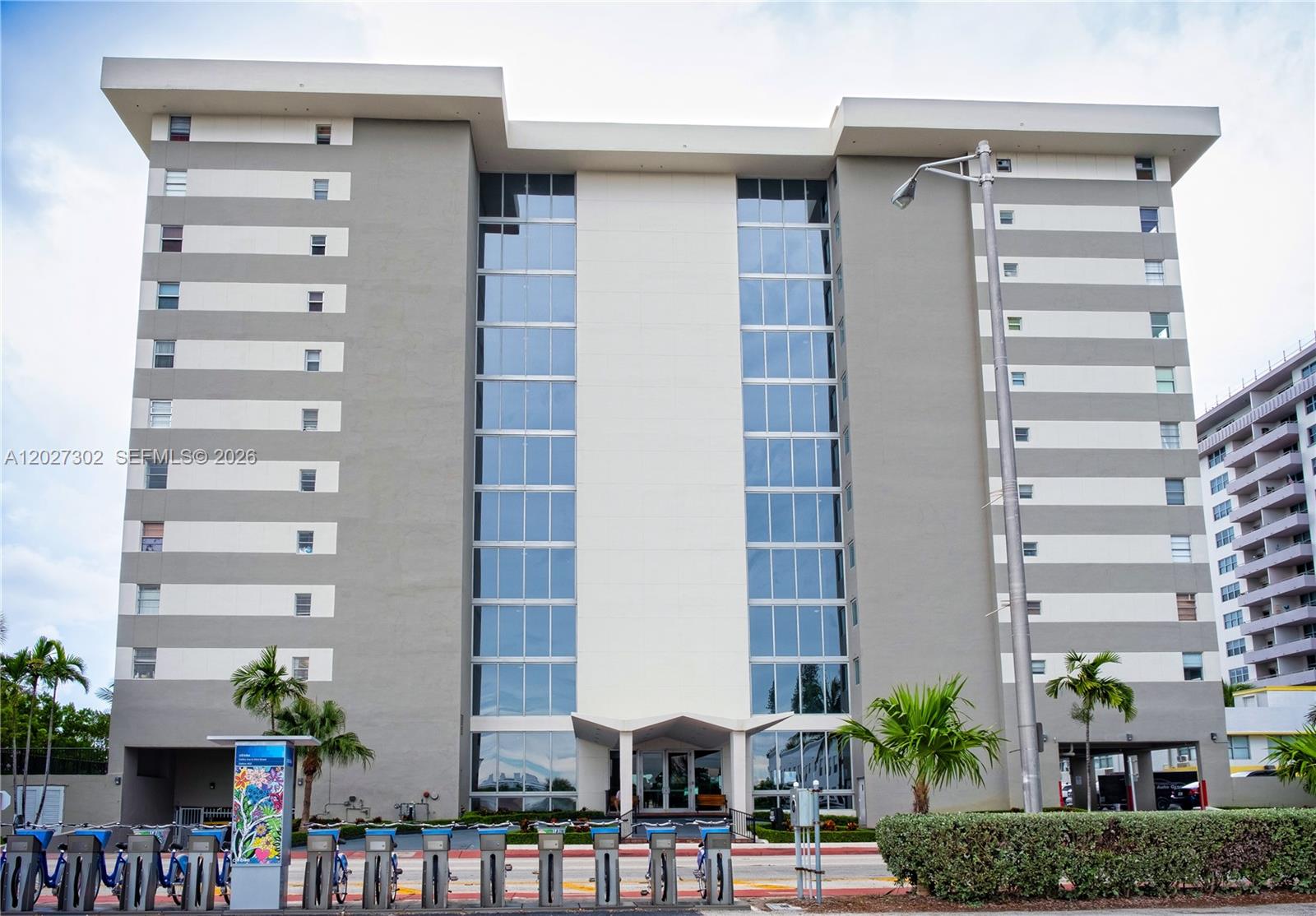 A multi-story apartment building with a central glass facade and a bike rental station — 9273 Collins Ave # 506, Surfside FL 33154, SURFSIDE, FL