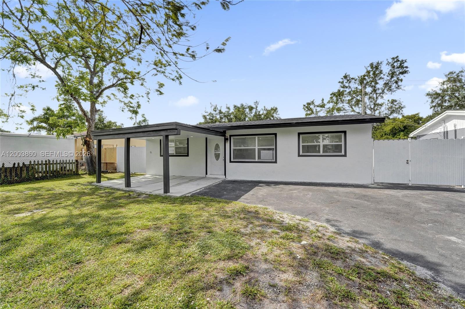 A single-story white house with a black-trimmed carport and a paved driveway — 6442 Oak St, Hollywood FL 33024, HOLLYWOOD, FL