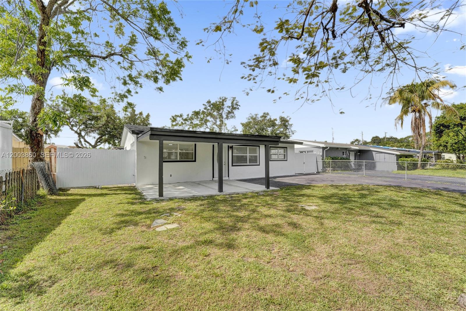 A single-story white house with a covered front porch and a large grassy yard — 6442 Oak St, Hollywood FL 33024, HOLLYWOOD, FL