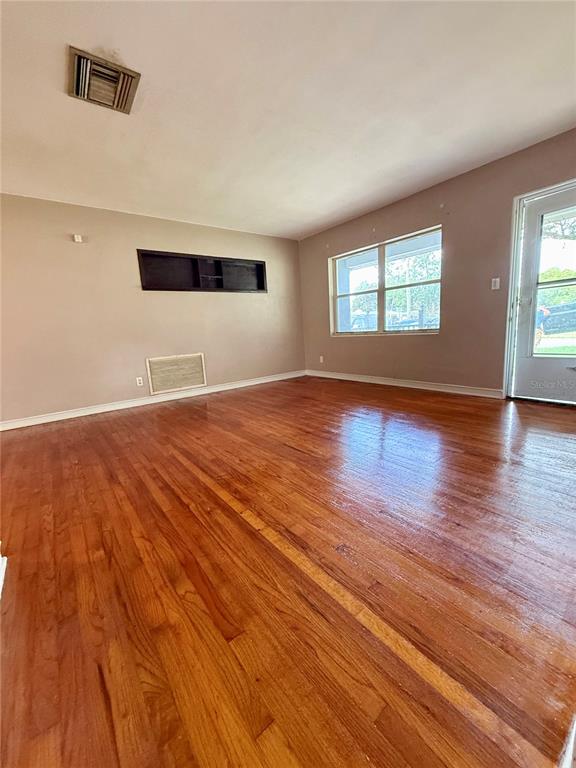 A living room with hardwood floors, a recessed wall niche, and a glass door — 1731 BALDWIN DRIVE, ORLANDO, FL