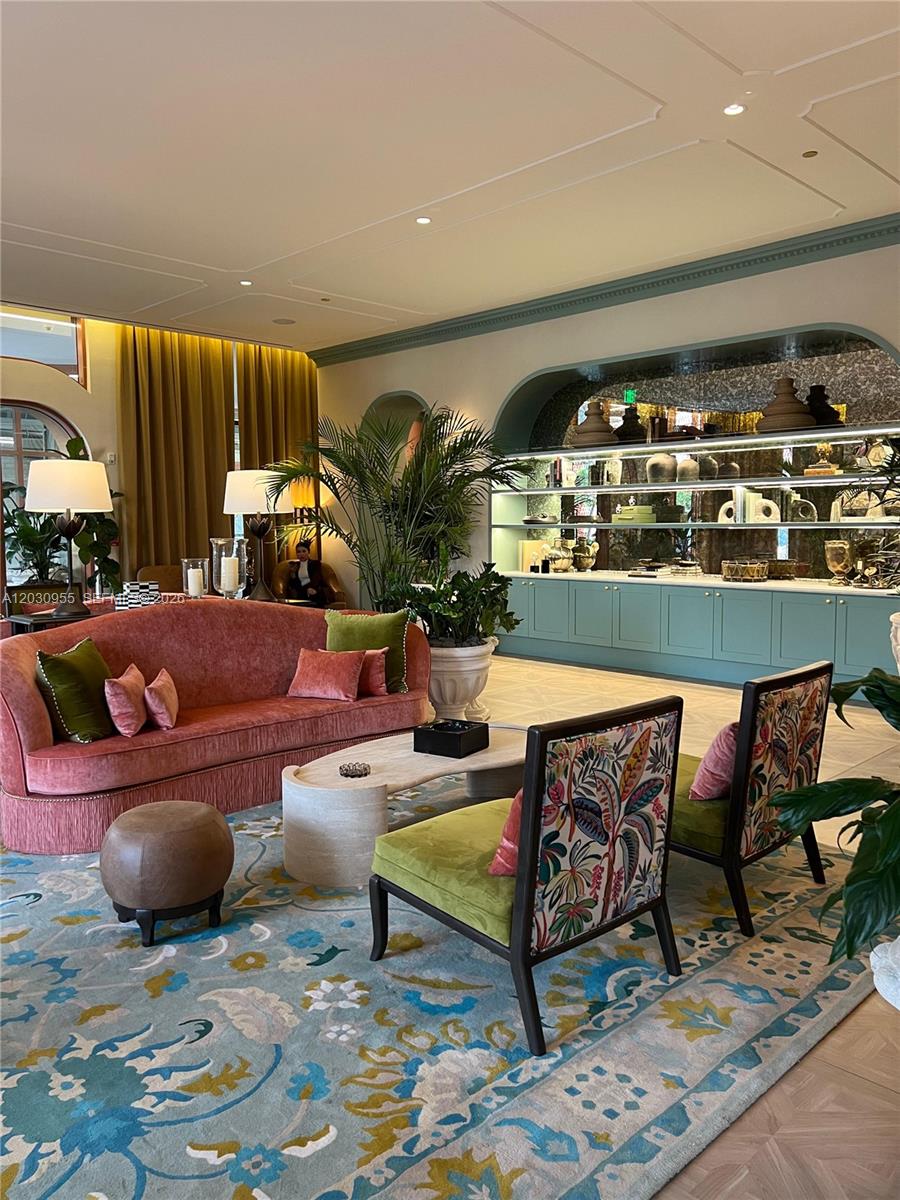 A living room features a pink curved sofa, patterned chairs, and built-in teal shelving — 2700 NW 2nd Avenue # 325, Miami FL 33127, MIAMI, FL
