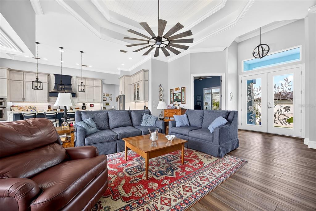 A living room with blue sofas, a brown leather chair, and a patterned area rug — 3520 ORIOLE DRIVE, PUNTA GORDA, FL