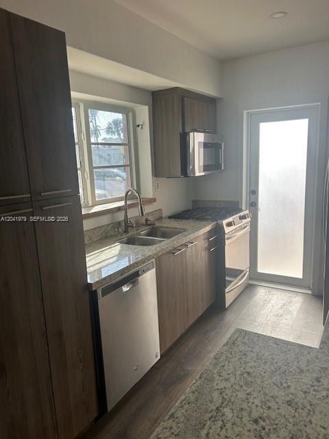 A modern kitchen features wood-toned cabinets, stainless steel appliances, and granite countertops — 1785 Calais Dr # 5, Miami Beach FL 33141, MIAMI BEACH, FL