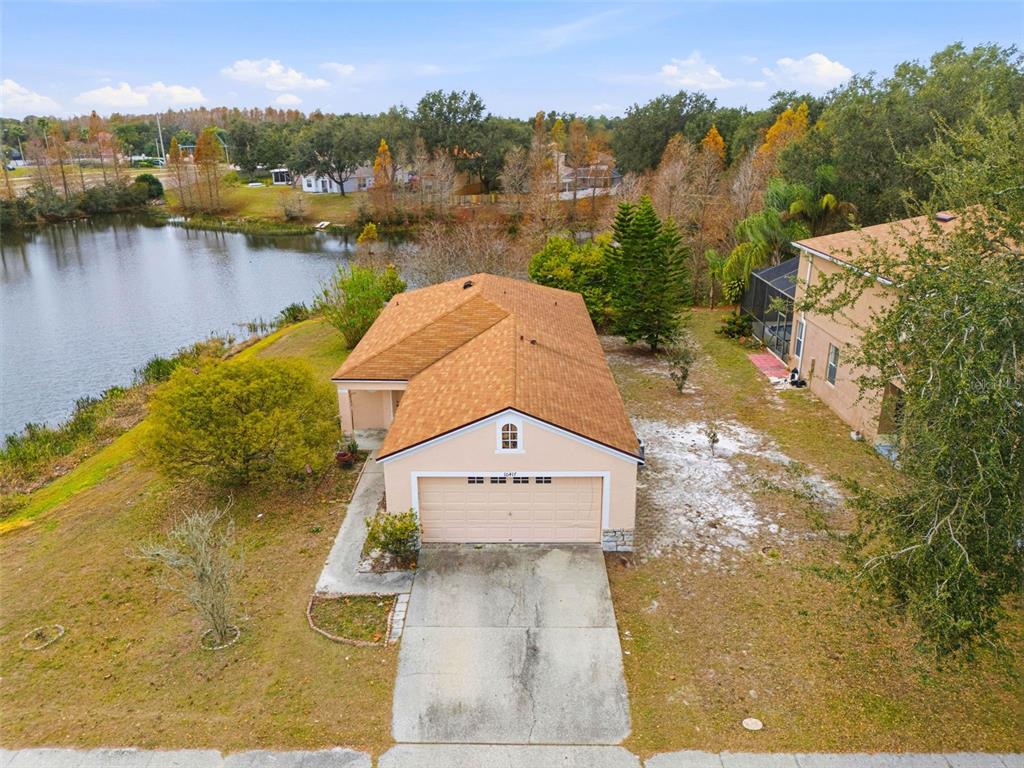 An aerial view of a tan single-story house with a two-car garage near a lake — 10417 BLACKMORE DRIVE, TAMPA, FL