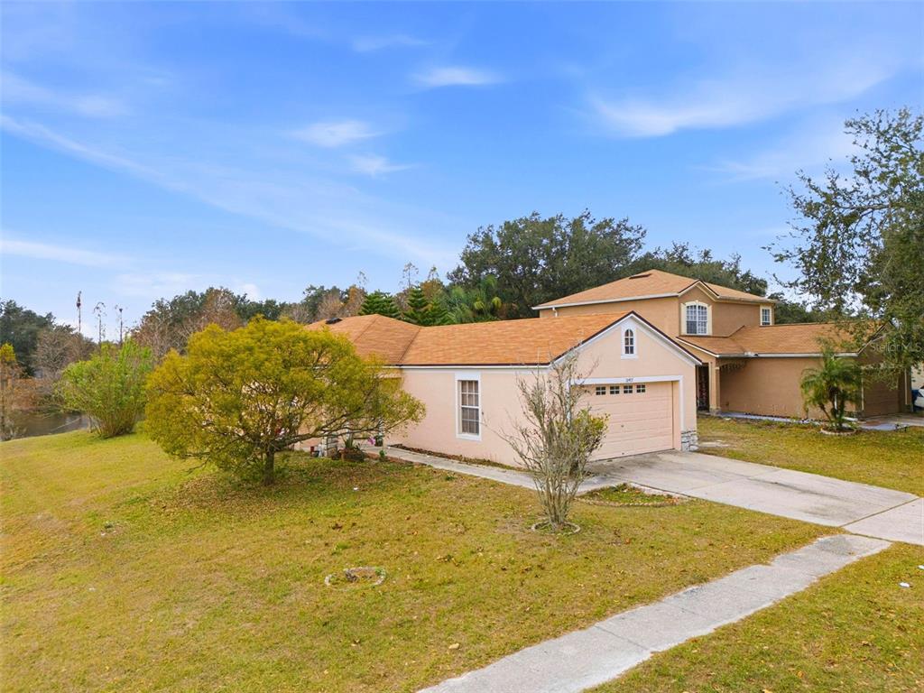 A tan, single-story house with a two-car garage and a large front yard — 10417 BLACKMORE DRIVE, TAMPA, FL