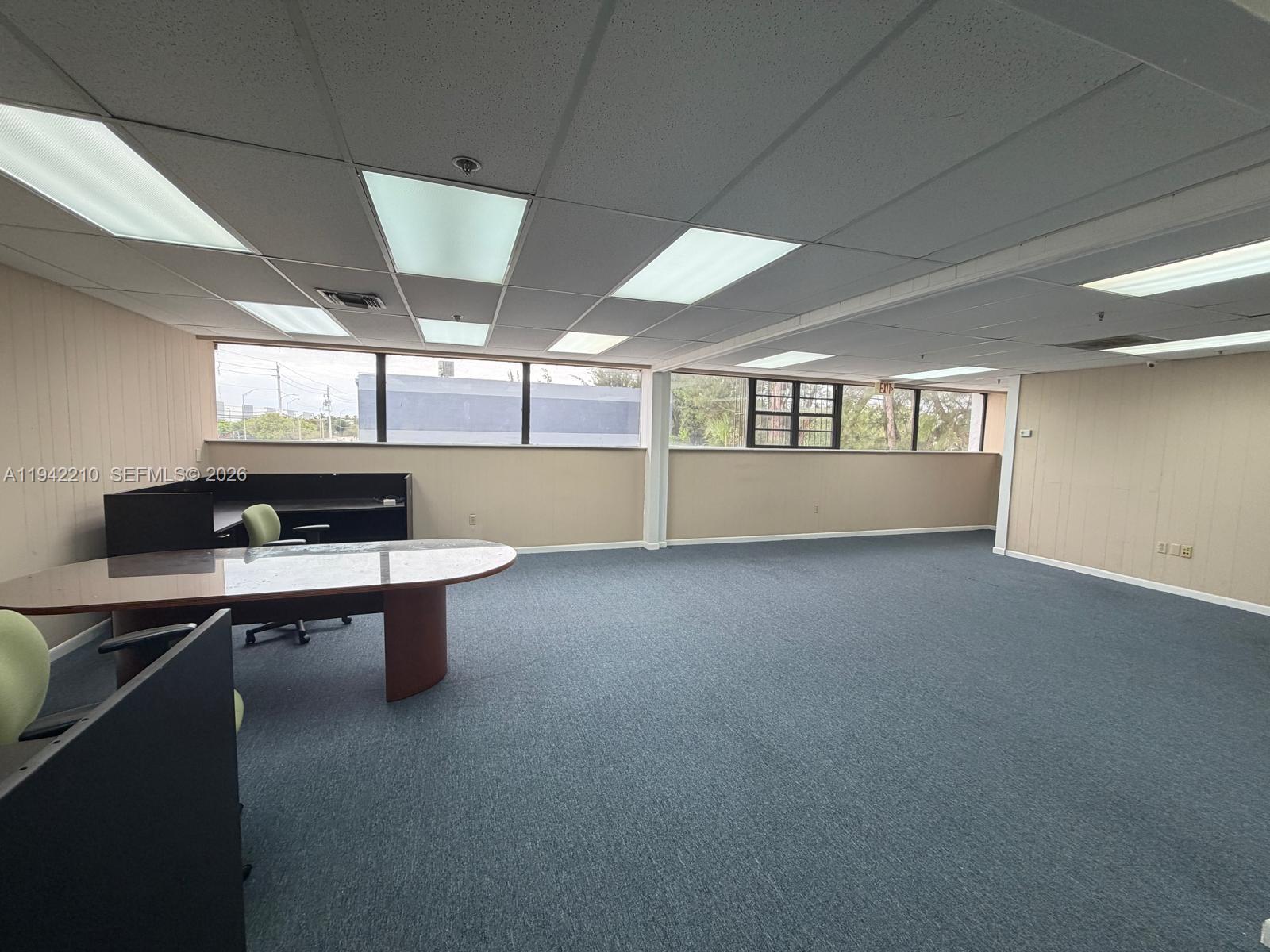 An office space features blue carpeting, beige walls, a drop ceiling, and large windows — 1355 NW 97 Avenue, Doral FL 33172, DORAL, FL
