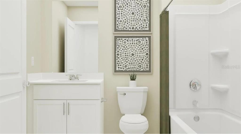 A bathroom features a white vanity, a toilet, and a shower-tub combination with white walls — 6611 CORAL VISTA DRIVE, RIVERVIEW, FL