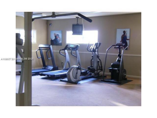 A gym features several pieces of cardio equipment, including treadmills and an elliptical machine — 18330 NW 68th Ave # A, Hialeah FL 33015, HIALEAH, FL