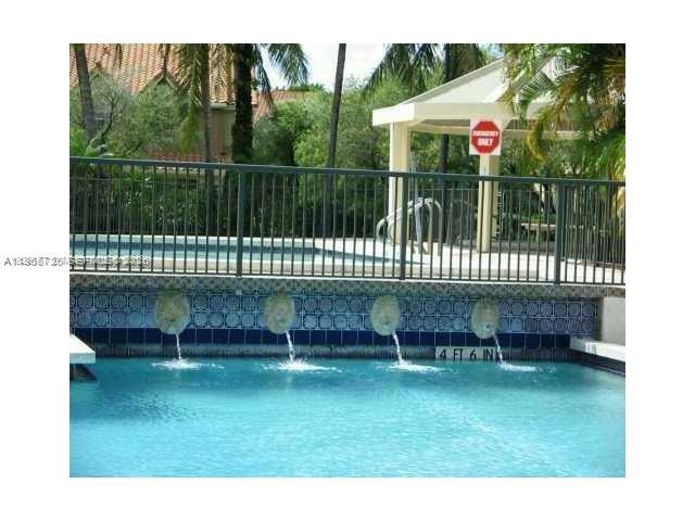 A swimming pool features four wall-mounted water fountains below a metal railing and gazebo — 18330 NW 68th Ave # A, Hialeah FL 33015, HIALEAH, FL