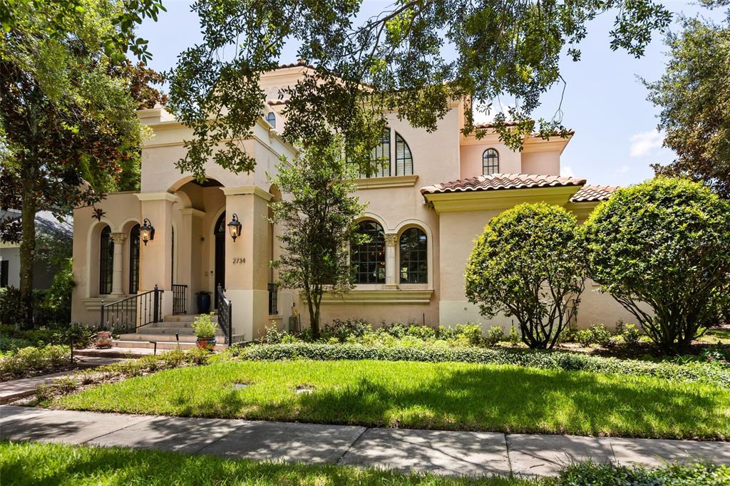 A two-story Mediterranean-style house with a stucco exterior, arched windows, and a tiled roof — 2734 MEETING PLACE, ORLANDO, FL