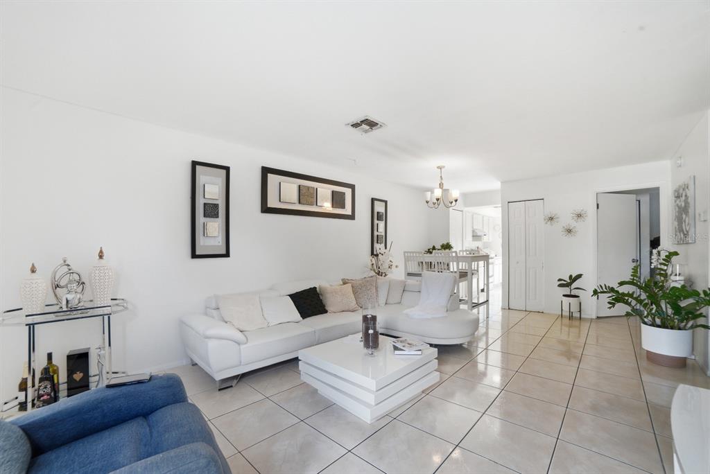 A living room features white tile floors, a white sectional sofa, and a coffee table — 2 E LAS PALMAS WAY, KISSIMMEE, FL