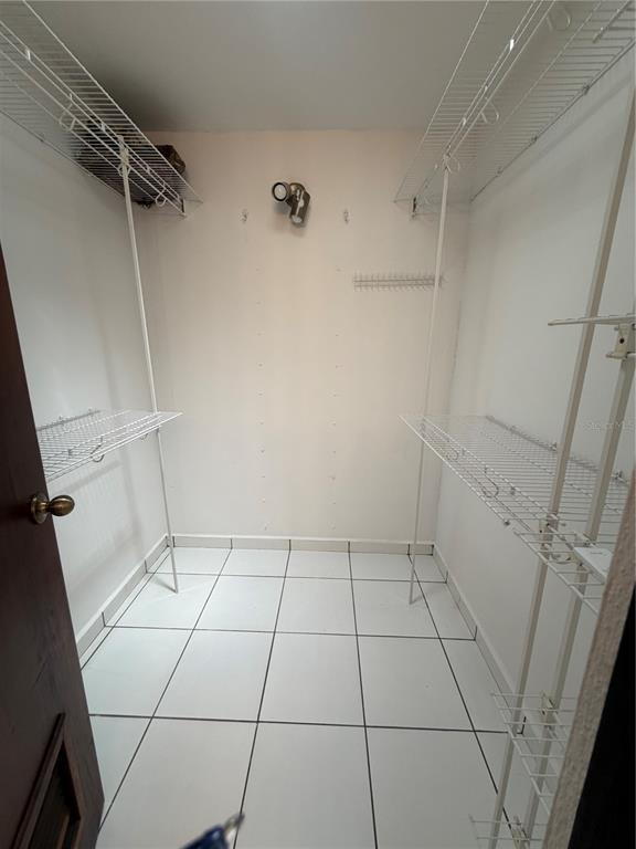 A walk-in closet with white tile flooring and wire shelving on both sides — G7 SICILIA, GUAYNABO, PR