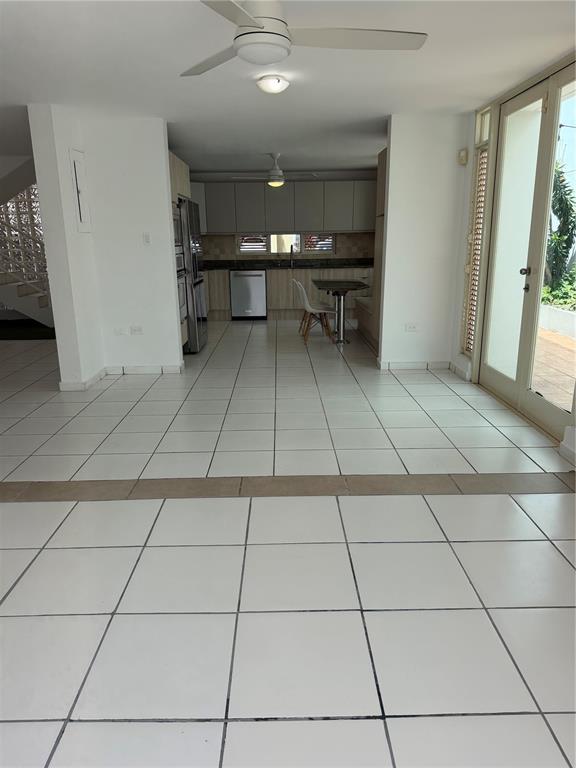 An open-concept kitchen and dining area features white tile flooring and a ceiling fan — G7 SICILIA, GUAYNABO, PR