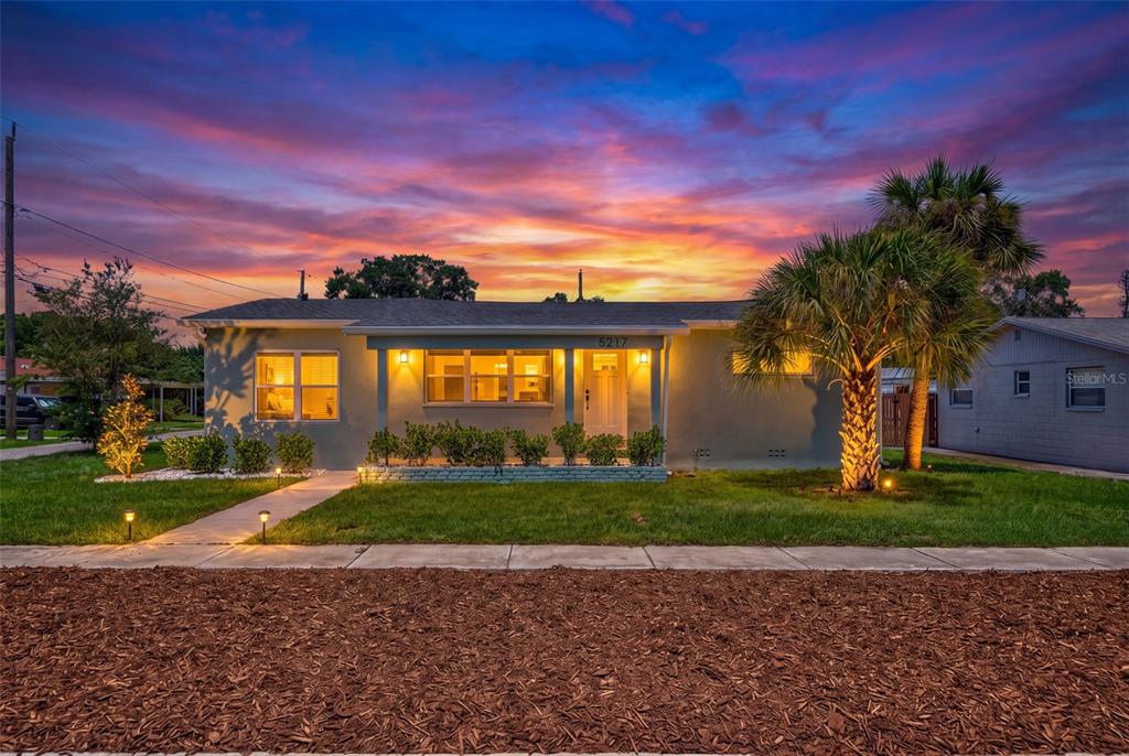 A single-story house with a gray exterior and a palm tree at sunset — 5217 18TH AVENUE S, GULFPORT, FL