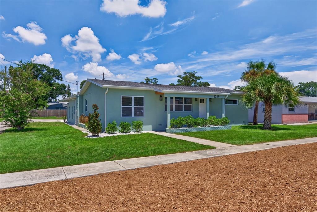 A light green single-story house with a covered front porch and a palm tree — 5217 18TH AVENUE S, GULFPORT, FL