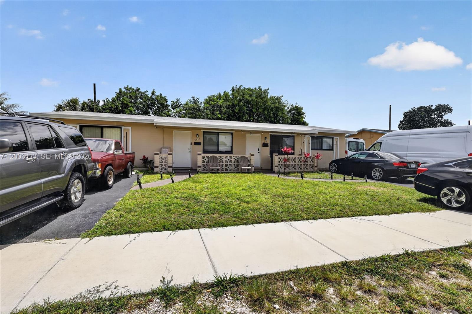 A single-story duplex with a front lawn, paved driveways, and decorative concrete block privacy walls — 5814 Cleveland St, Hollywood FL 33021, HOLLYWOOD, FL