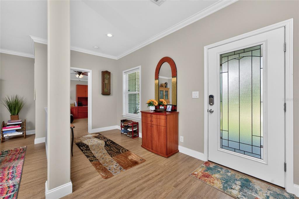 An entryway features wood-look flooring, a white front door with glass, and a wooden cabinet — 308 W GRACE STREET, PUNTA GORDA, FL