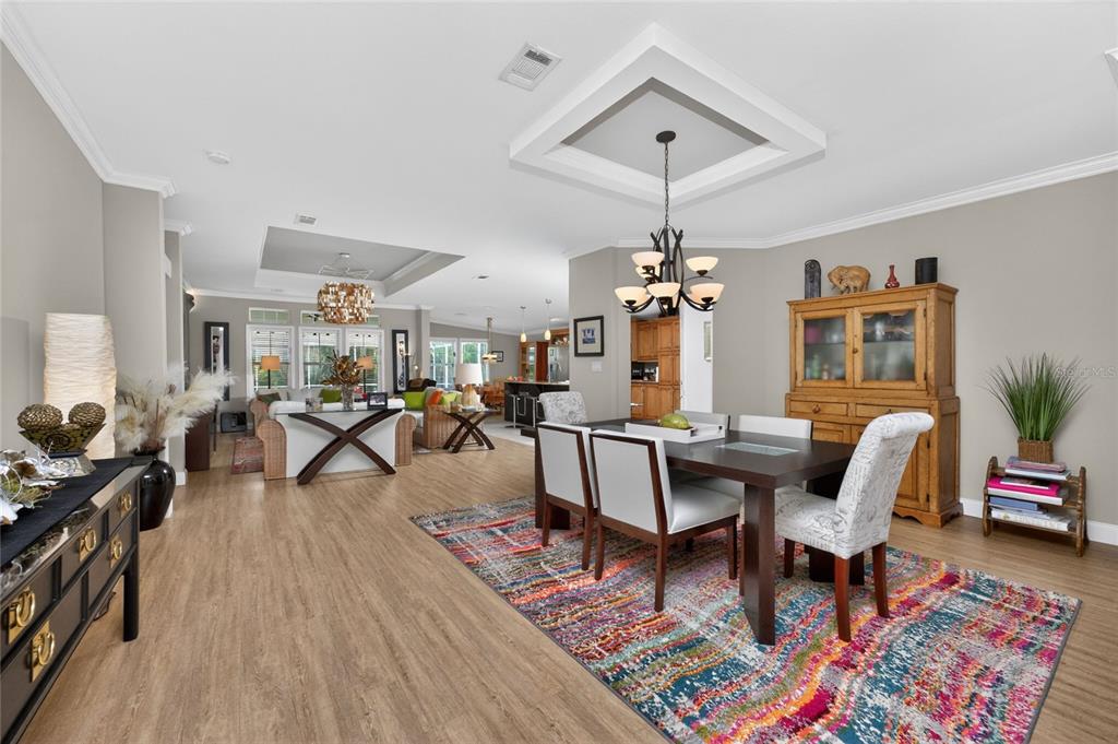 A dining area with a wooden table and chairs sits on a colorful patterned rug — 308 W GRACE STREET, PUNTA GORDA, FL