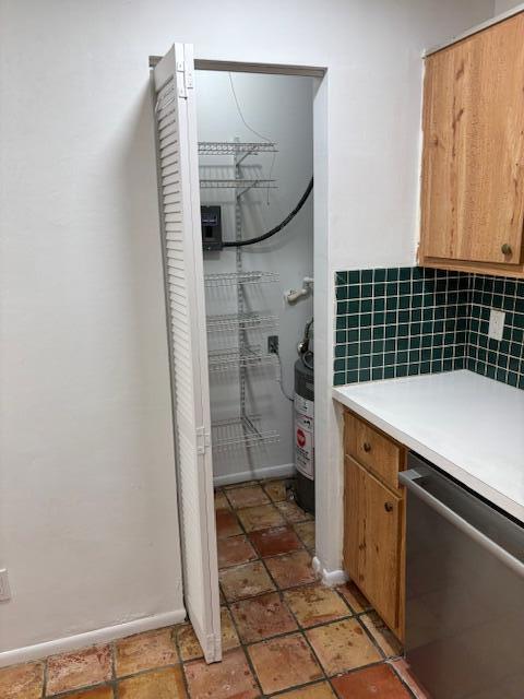 A kitchen pantry with wire shelving and a water heater behind white louvered doors — 101 Harvest Moon Court # C, Jupiter FL 33458, JUPITER, FL