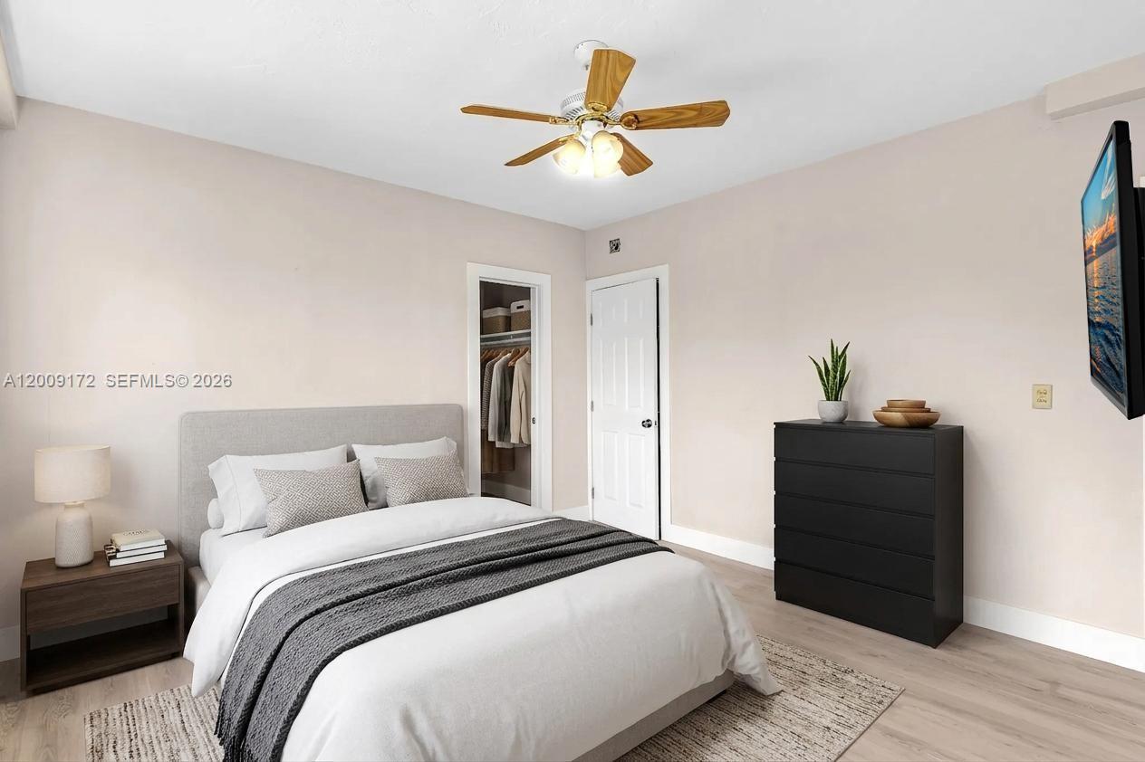 A bedroom features a bed with a gray headboard, a black dresser, and a ceiling fan — 1165 Marseille Dr # 19, Miami Beach FL 33141, MIAMI BEACH, FL