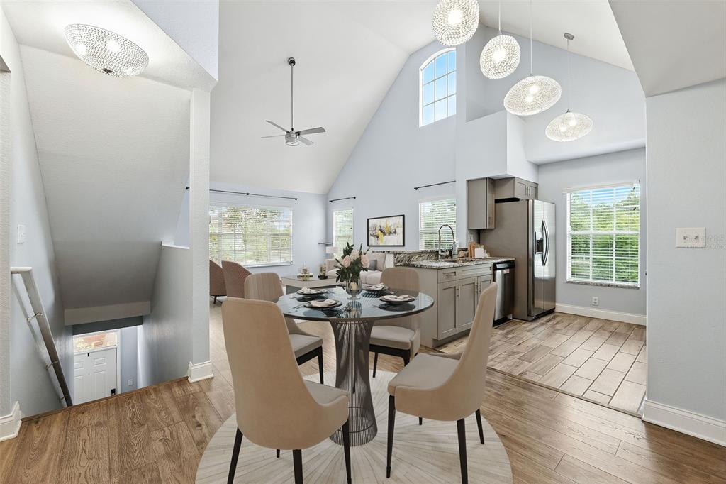 A dining area with a round table and chairs sits beneath a vaulted ceiling — 9368 LAKE CHASE ISLAND WAY UNIT 9368, TAMPA, FL