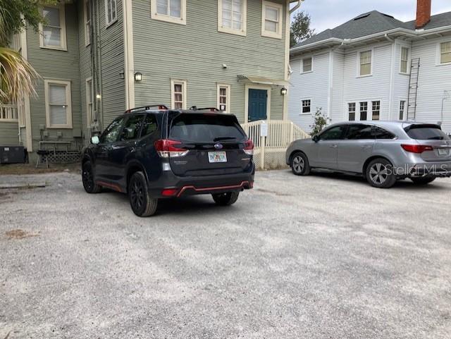 Two cars are parked on a gravel lot in front of two multi-story houses — 806 W DE LEON STREET, TAMPA, FL