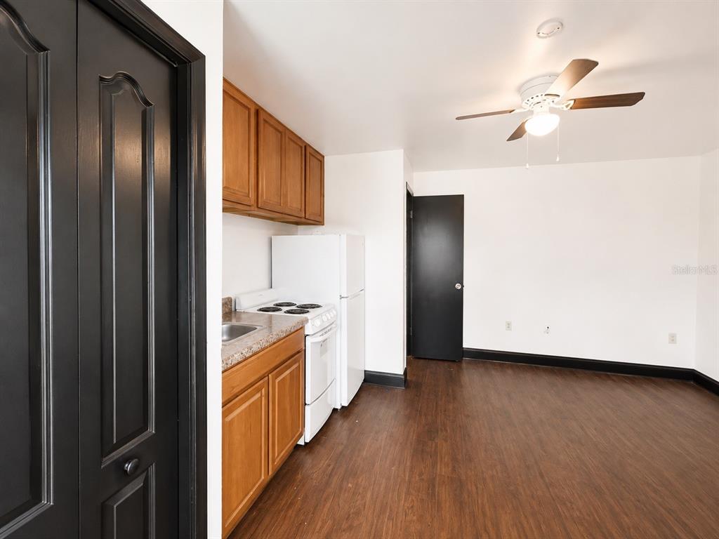 A kitchen area with wood cabinets, a white stove, and a refrigerator in a room — 2795 L B MCLEOD ROAD UNIT A, ORLANDO, FL