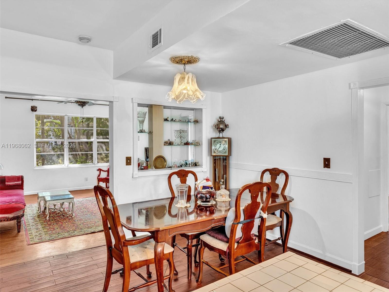 A dining room features a wooden table, chairs, a built-in display niche, and hardwood floors — 503 12th St # 5, Miami Beach FL 33139, MIAMI BEACH, FL