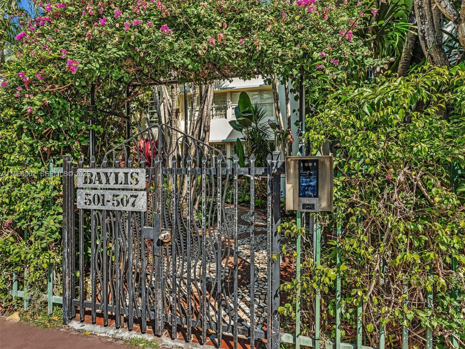 A black metal gate with a sign reading Baylis 501-507 stands before a lush garden — 503 12th St # 5, Miami Beach FL 33139, MIAMI BEACH, FL