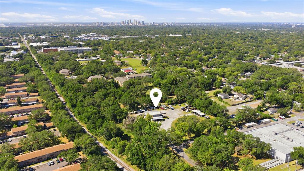 An aerial view shows a commercial property marked with a pin amidst a wooded area — 2415 E SLIGH AVENUE, TAMPA, FL