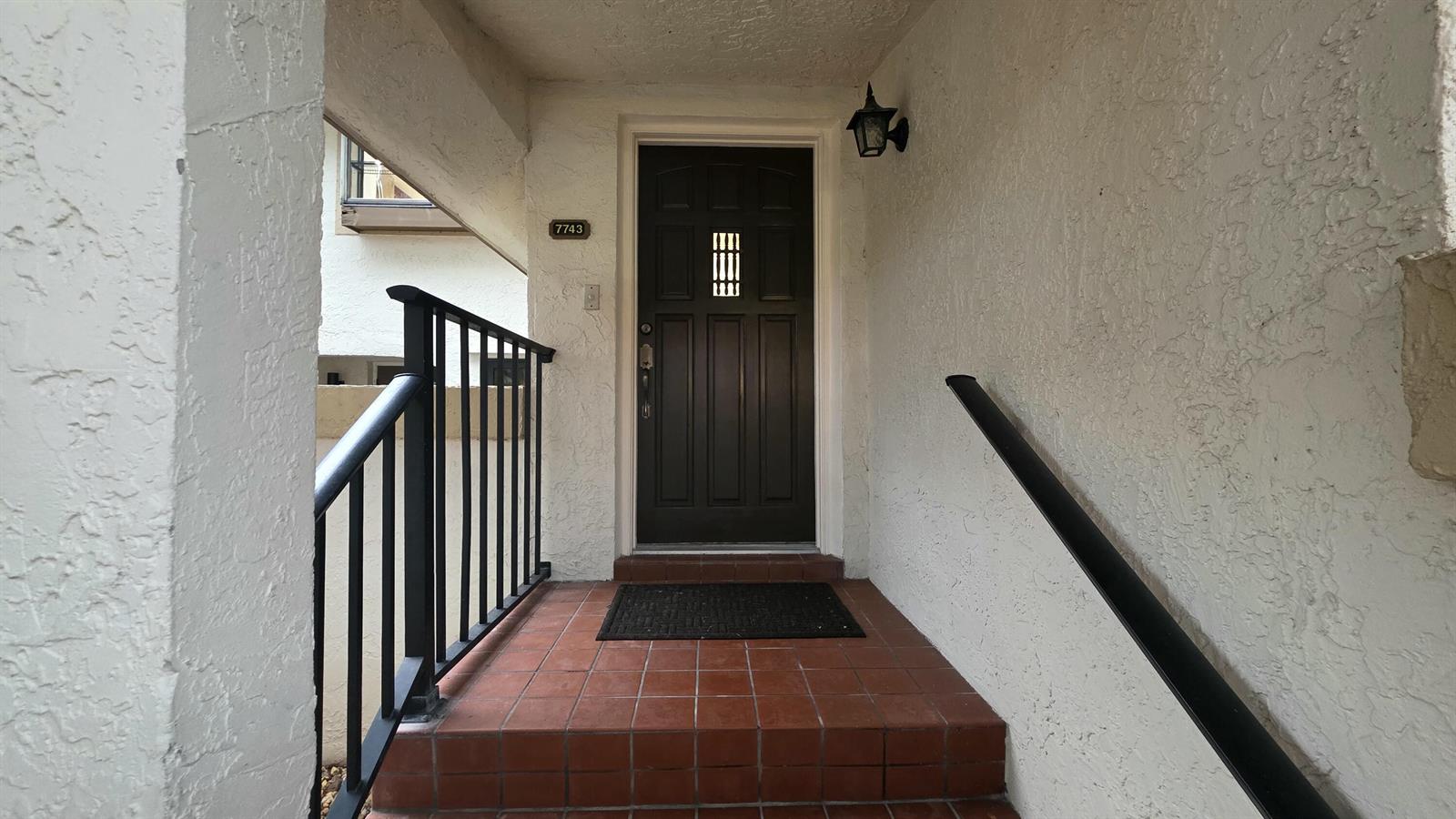 A dark front door with a small window sits at the top of tiled steps — 7743 La Mirada Drive, Boca Raton FL 33433, BOCA RATON, FL