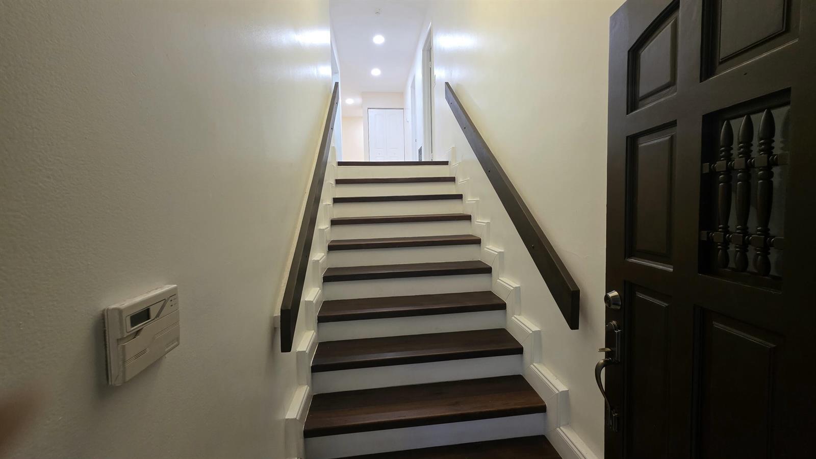 A staircase with dark wood treads and white risers leads to an upper hallway — 7743 La Mirada Drive, Boca Raton FL 33433, BOCA RATON, FL