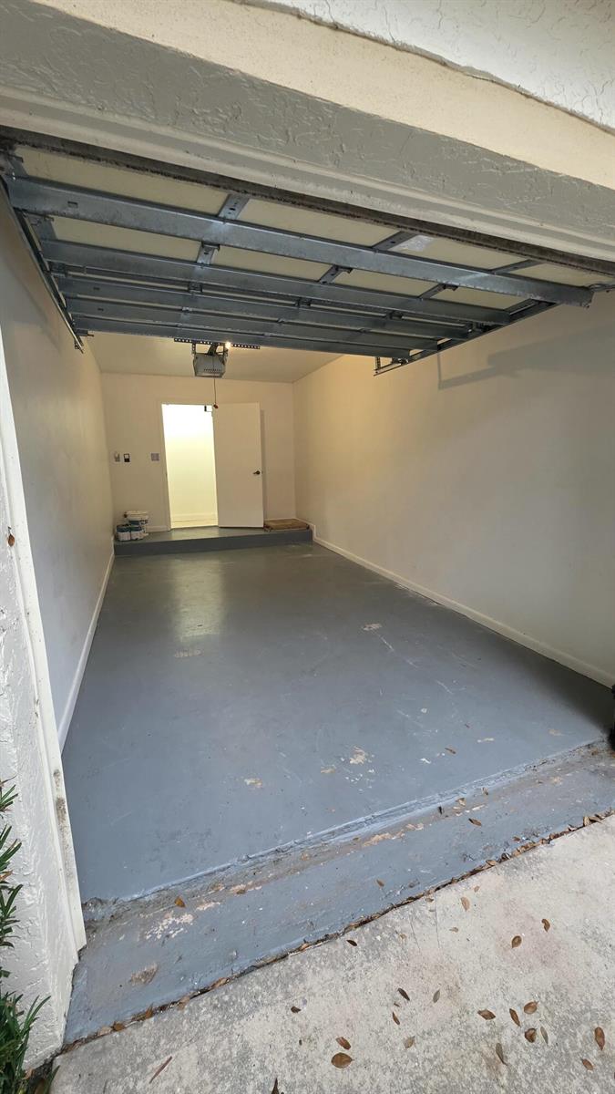 An empty garage with a gray painted concrete floor, white walls, and an open door — 7743 La Mirada Drive, Boca Raton FL 33433, BOCA RATON, FL