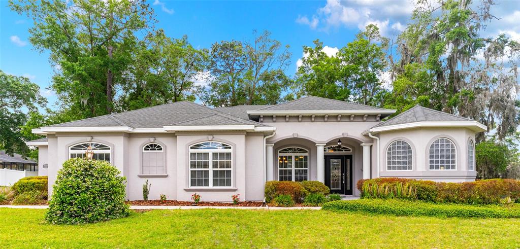 A single-story house with a light-colored stucco exterior, a gray roof, and a front porch — 4518 SE 33RD PLACE, OCALA, FL