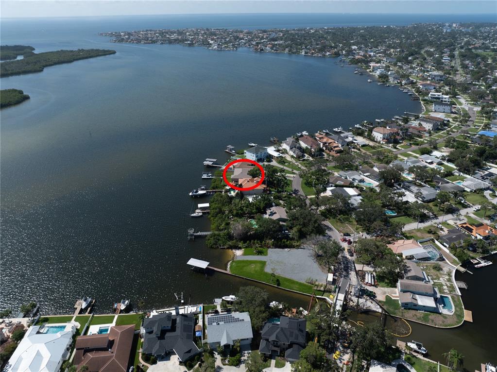 An aerial view shows a waterfront house with a red circle highlighting the property — 6663 BAYOU GRANDE BOULEVARD NE, ST PETERSBURG, FL
