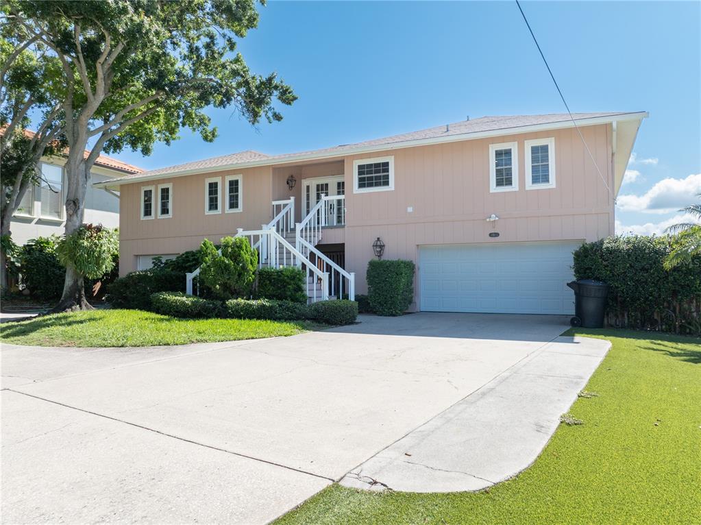 A two-story house with light-colored siding, a white staircase, and a two-car garage — 6663 BAYOU GRANDE BOULEVARD NE, ST PETERSBURG, FL