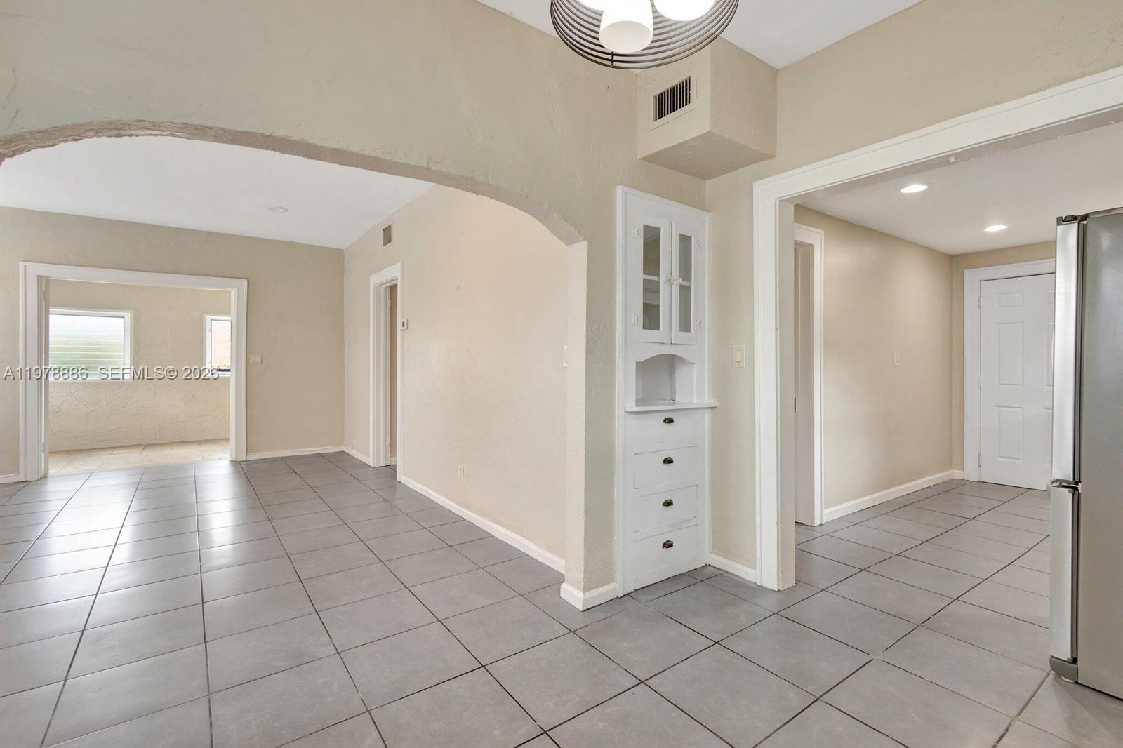 A tiled room features an arched entryway, a white built-in cabinet, and recessed lighting — 630 33rd St # 0, West Palm Beach FL 33407, WEST PALM BEACH, FL