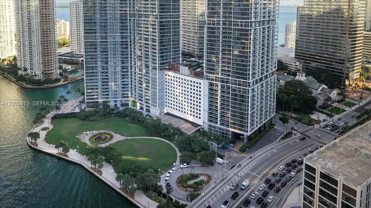 An aerial view shows high-rise apartment buildings overlooking a waterfront park and a city street — 465 Brickell Ave # 3804, Miami FL 33131, MIAMI, FL