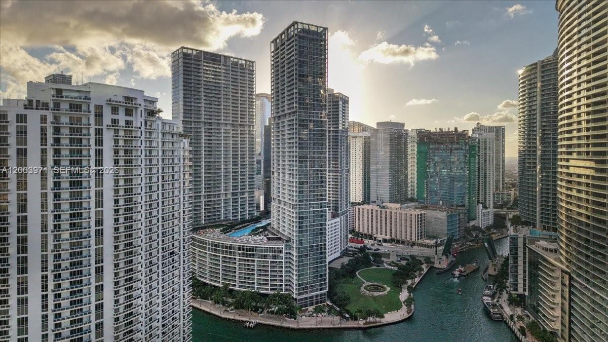 An aerial view of a dense urban waterfront with multiple high-rise apartment buildings and parks — 465 Brickell Ave # 3804, Miami FL 33131, MIAMI, FL