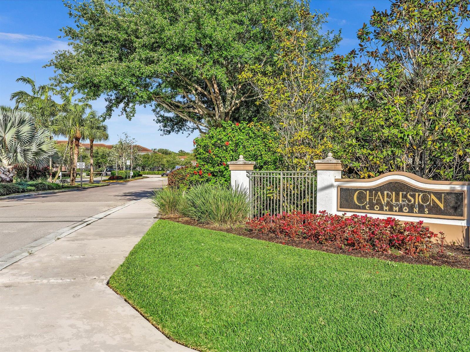 A sign for Charleston Commons stands beside a sidewalk, green lawn, and mature trees — 4316 Maybelle Lane, West Palm Beach FL 33417, WEST PALM BEACH, FL