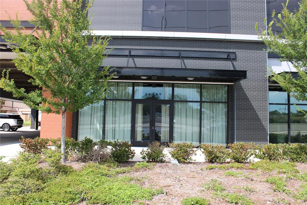 The exterior of a modern commercial building features a glass-paned entrance with a black awning — 26489 US HIGHWAY 19 N UNIT 1, CLEARWATER, FL