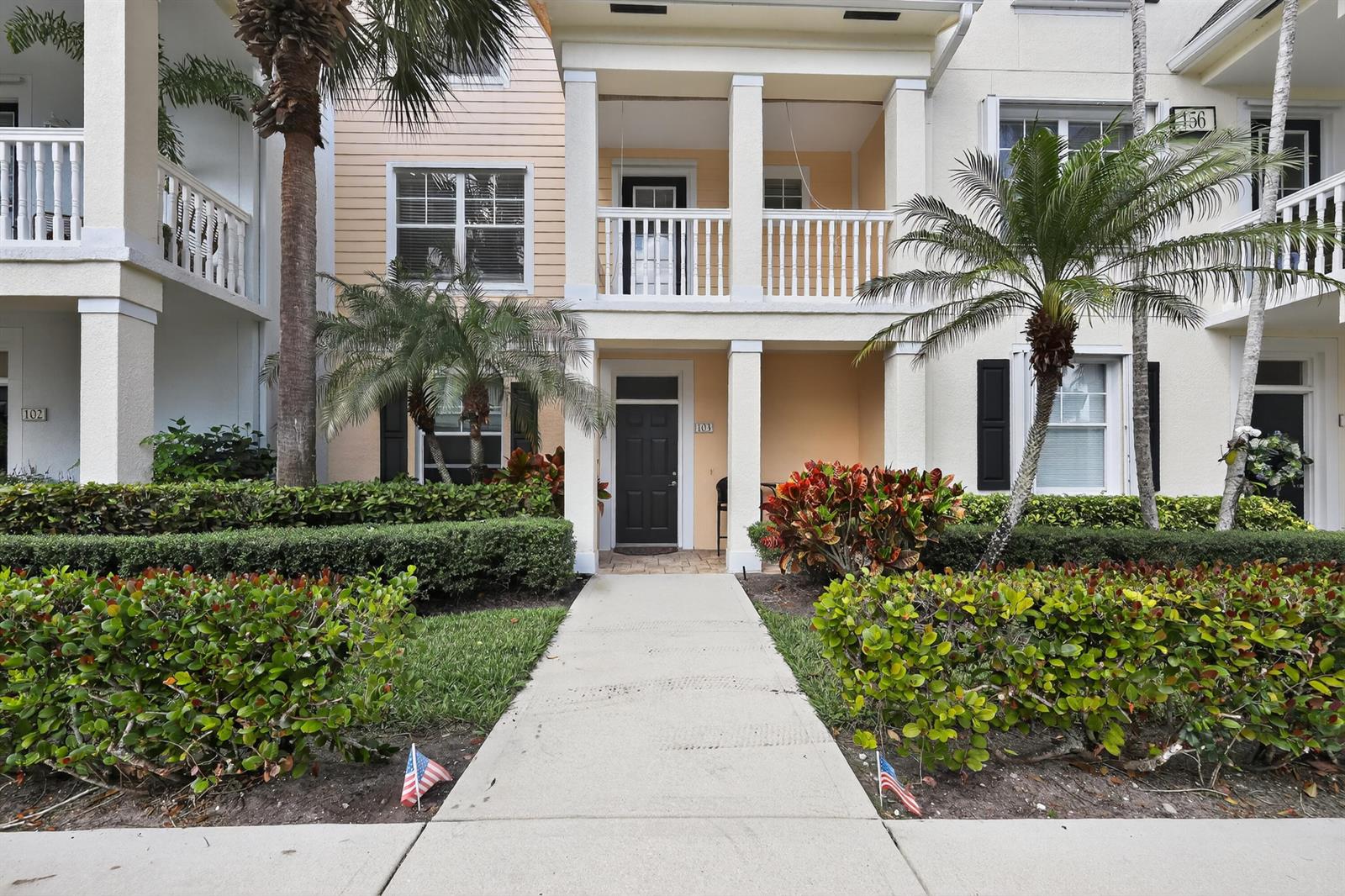 A concrete walkway leads to the front entrance of a multi-story residential building — 156 Aragon Way, Jupiter FL 33458, JUPITER, FL