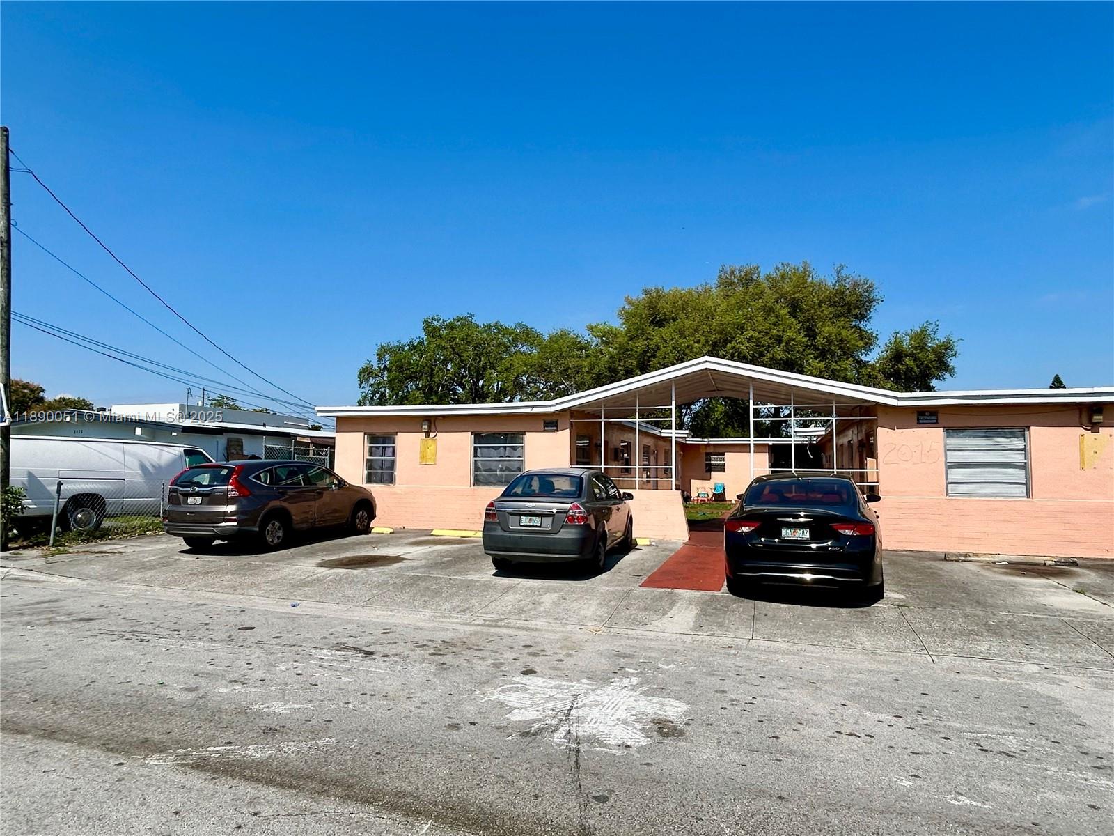 A single-story peach-colored building with a covered central entryway and a paved parking lot — 2013 Washington Ave, Opa-Locka FL 33054, OPA-LOCKA, FL