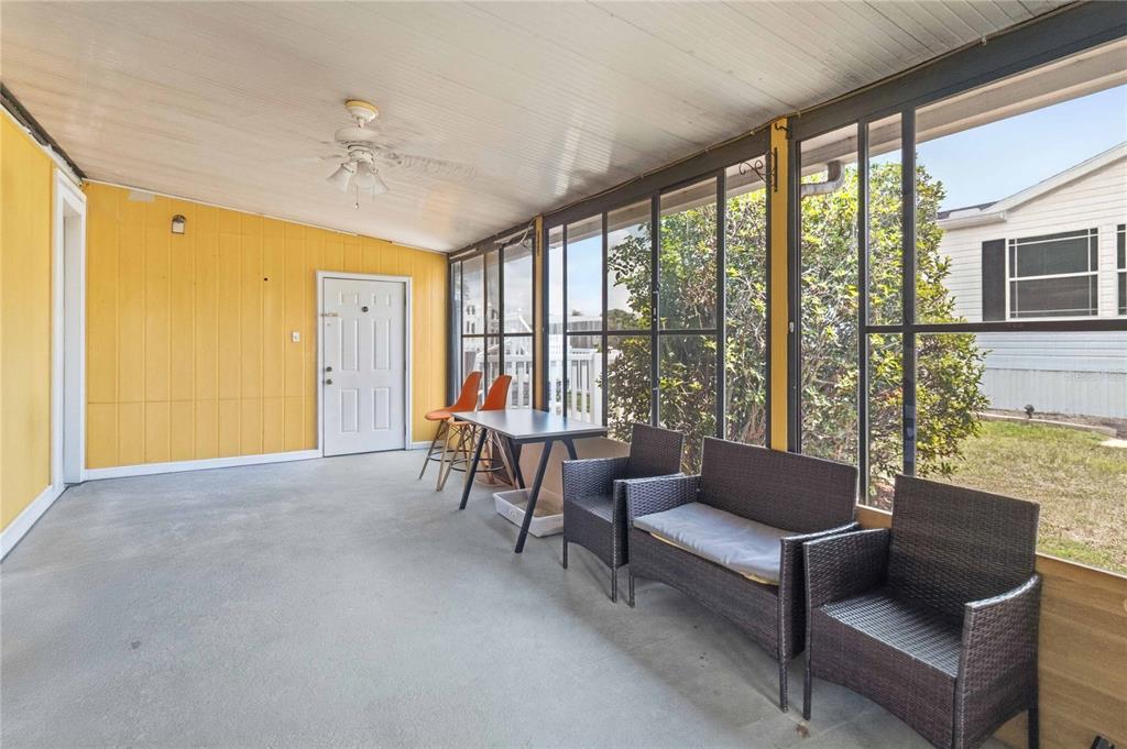 A screened-in porch with yellow walls, a concrete floor, and outdoor furniture — 2030 CRYSTAL LANE, ST CLOUD, FL