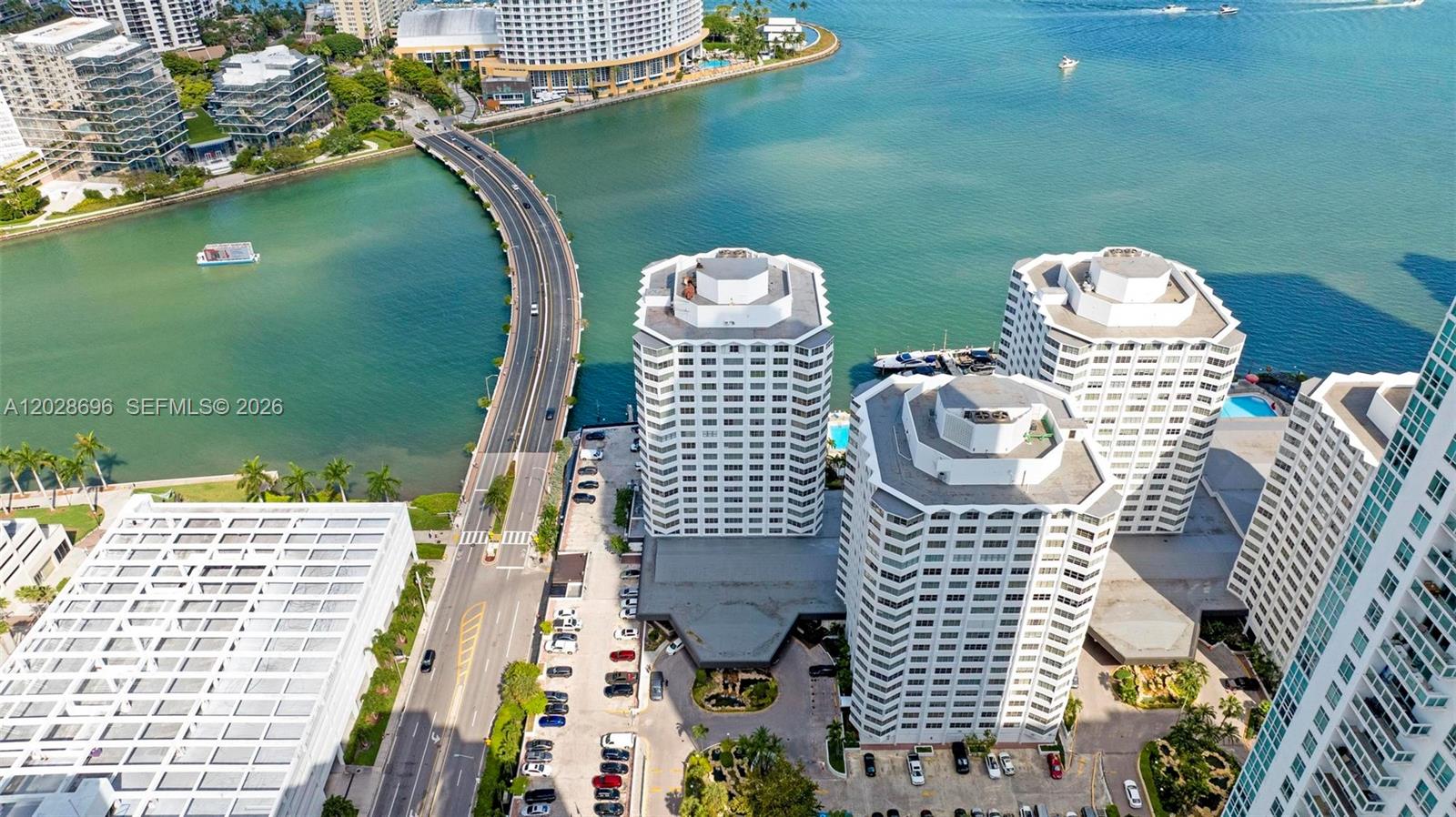 An aerial view shows high-rise apartment buildings, a curved bridge, and a waterway — 801 Brickell Bay Dr # 361, Miami FL 33131, MIAMI, FL